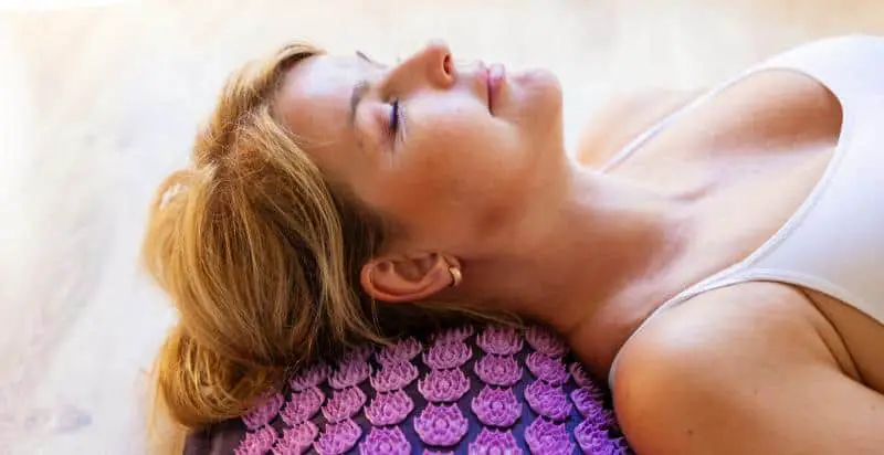Woman lying on an acupressure mat