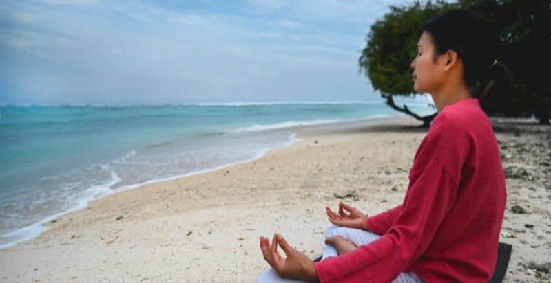 A girl meditating on the beach