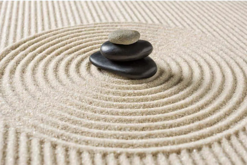 Concentric designs around smooth and beautifully colored rocks in a Mini Zen Garden